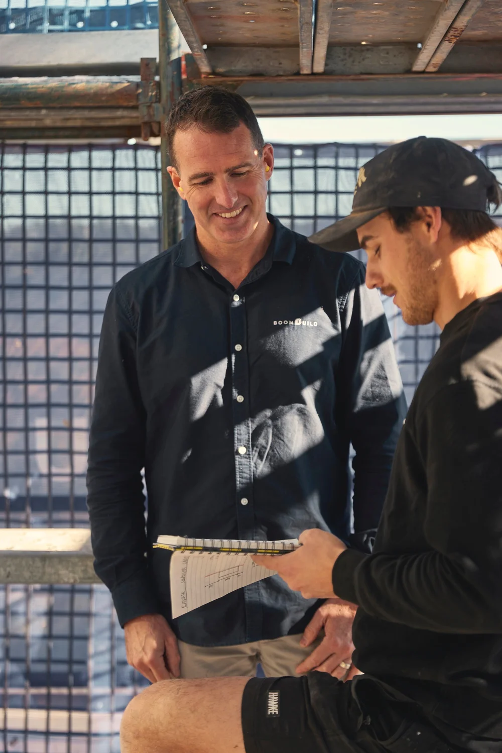 Ben Carty reviewing plans with a tradesperson on a residential building site